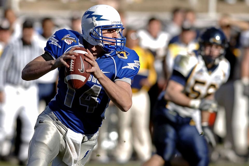 A football player holding a ball and looking at the camera.