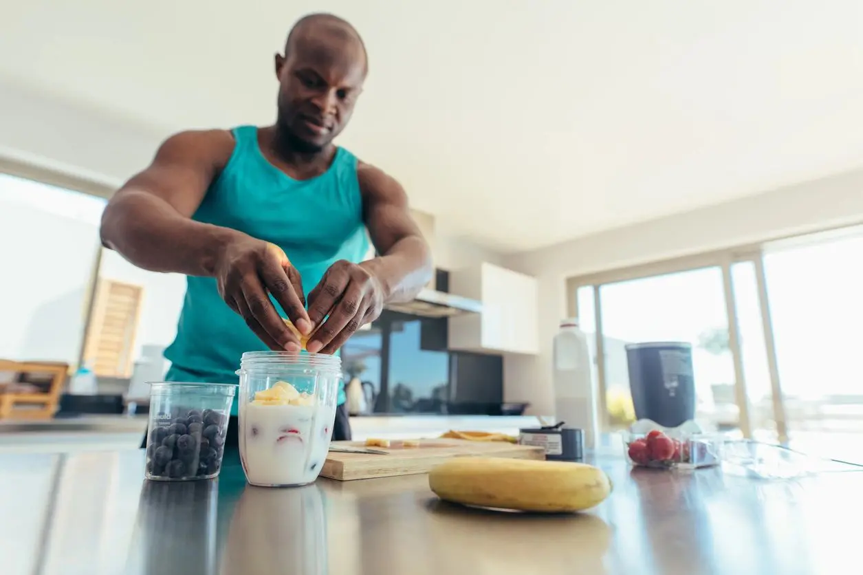 A man is preparing food in the kitchen.